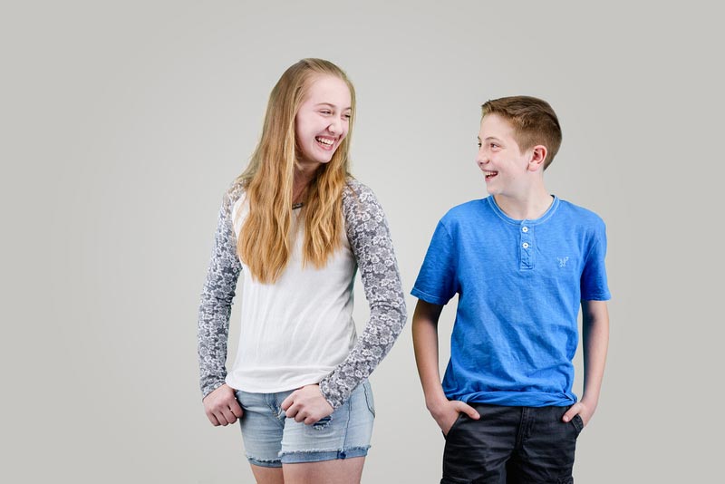 two siblings smiling at each other