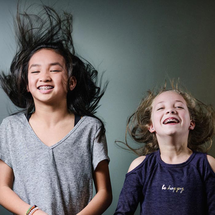two girls laughing with braces